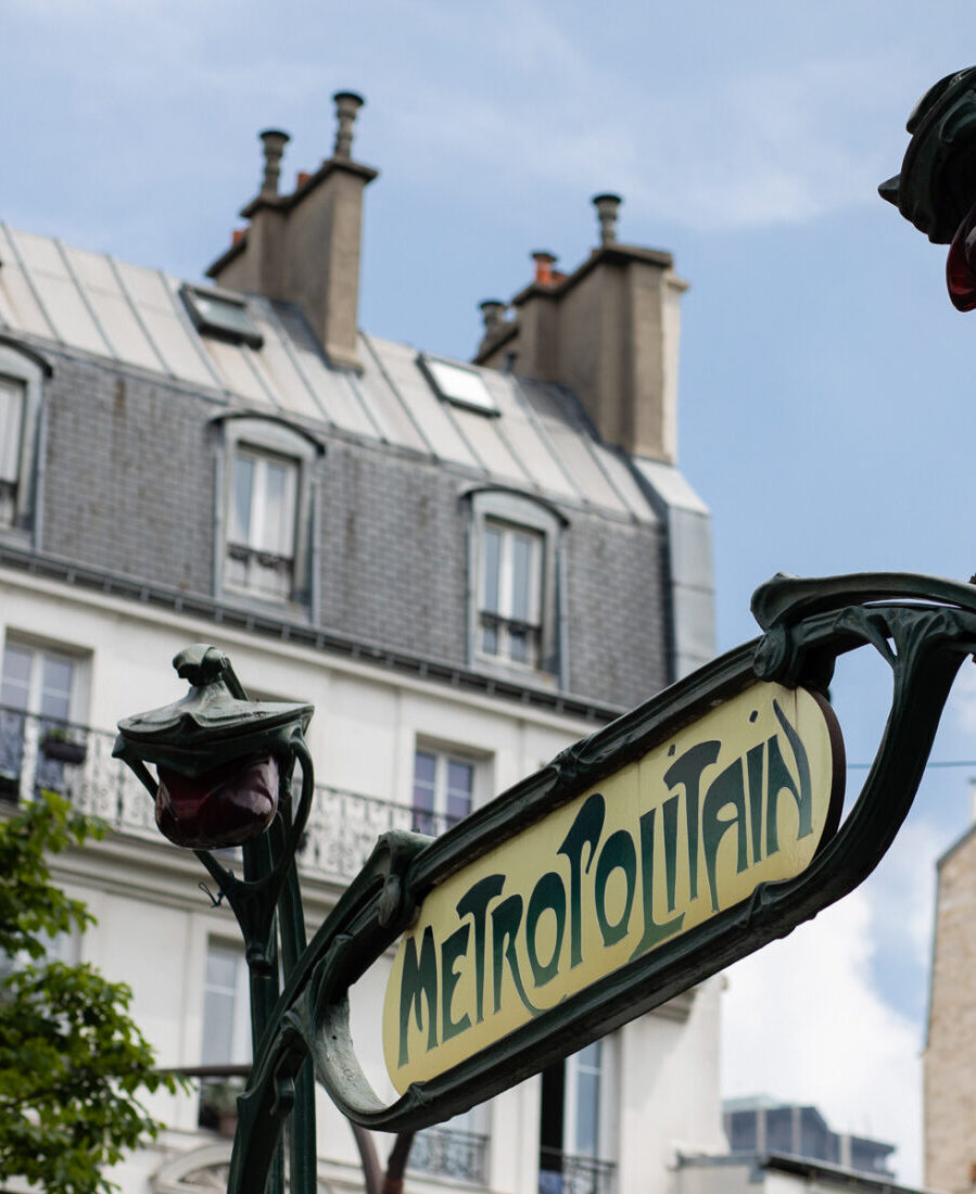 Entrée de métro « Métropolitain » devant un immeuble parisien